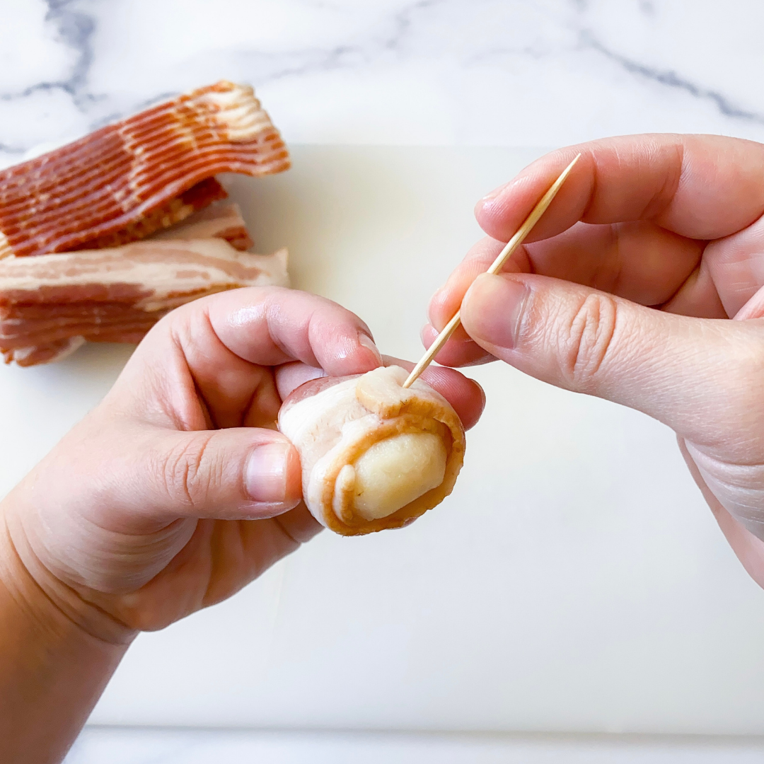 secure bacon wrapped water chestnuts with a toothpick
