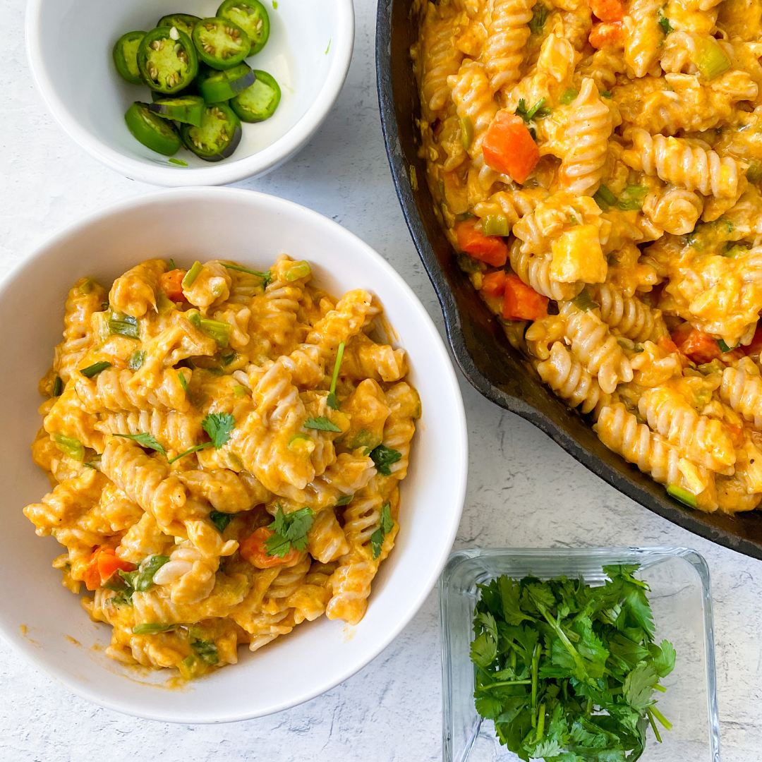 bowl of buffalo chicken pasta bake with jalapeno slices and cilantro